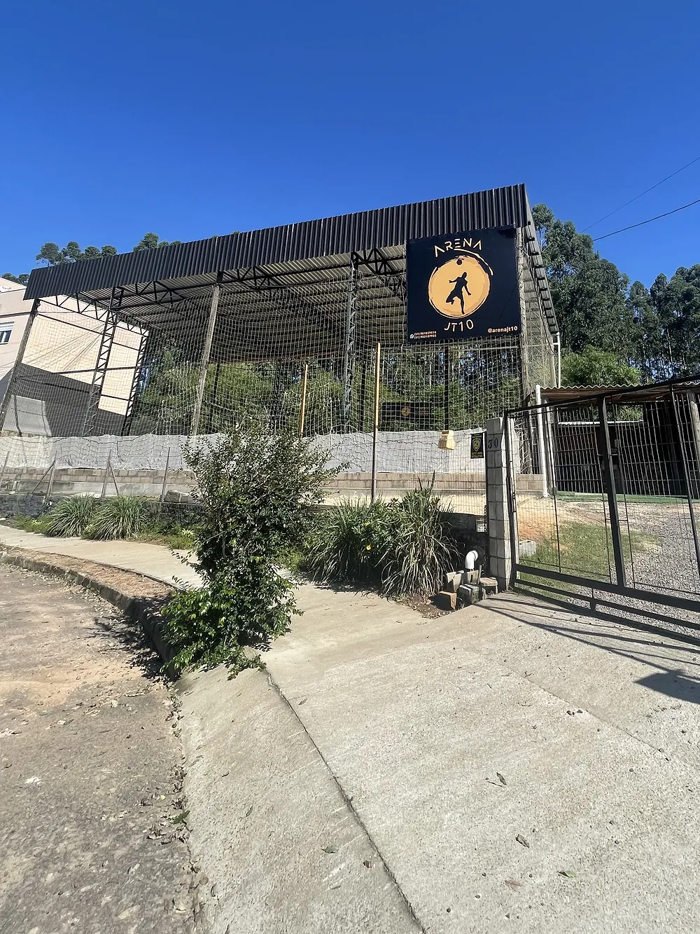 Fachada da Arena JT10 vista da rua, com a cobertura preta da quadra