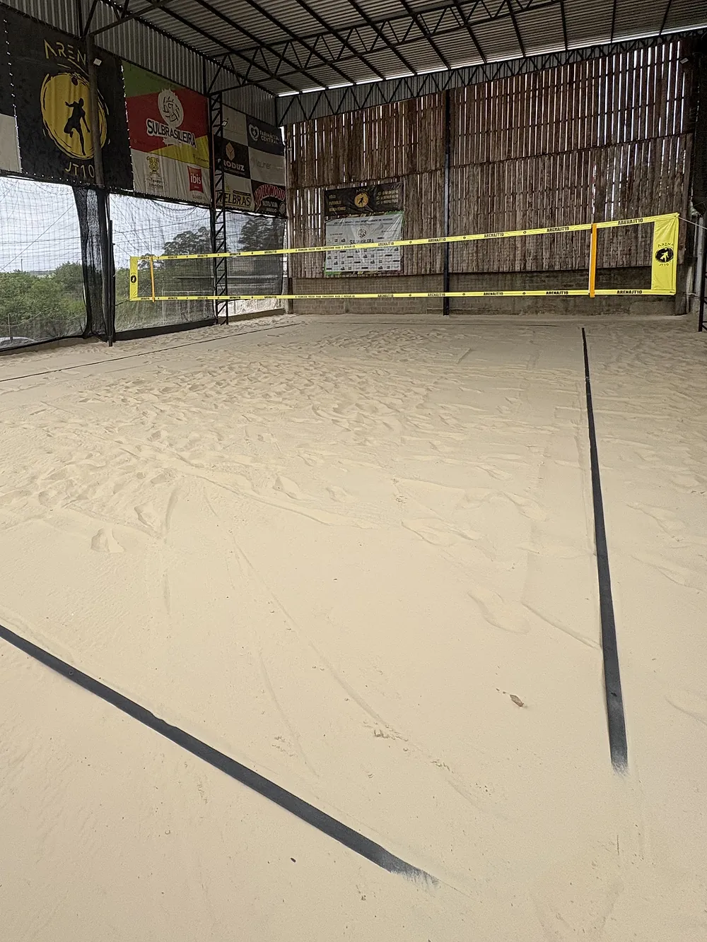 Quadra de areia coberta da Arena JT10, com a areia lisa antes do jogo